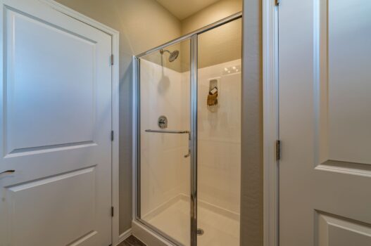 Model bathroom at our townhomes for rent in Queen Creek, AZ, featuring a shower with sliding glass doors.