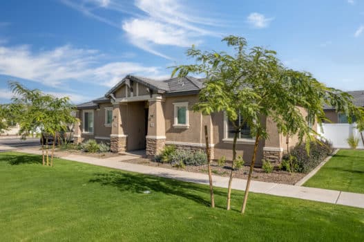 The grounds at our apartments in Queen Creek, featuring green lawns, trees, and a view of the building exteriors.