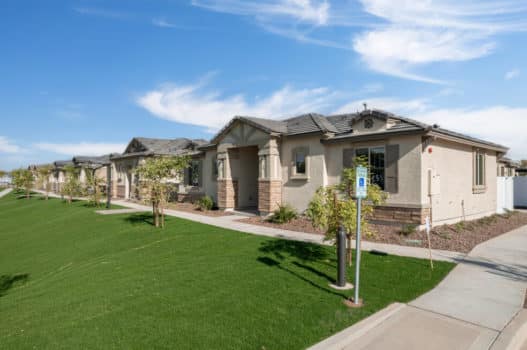 The grounds at our apartments in Queen Creek, featuring green lawns, trees, and a view of the building exteriors.